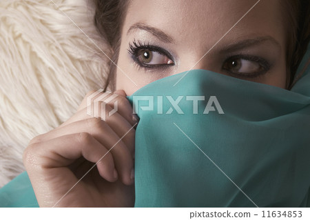 Close up of woman holding veil over lower half of face 11634853
