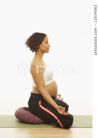 Pregnant Mixed Race woman meditating Pregnant Mixed Race woman meditating 11634862
