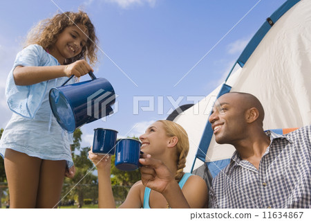 Hispanic girl pouring coffee for parents 11634867