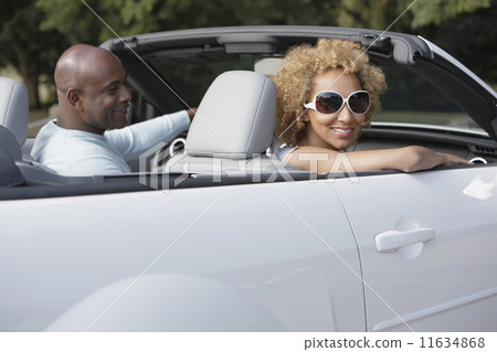 African couple driving convertible car 11634868