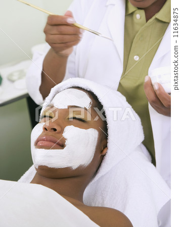 African woman receiving spa facial treatment African woman receiving spa facial treatment 11634875