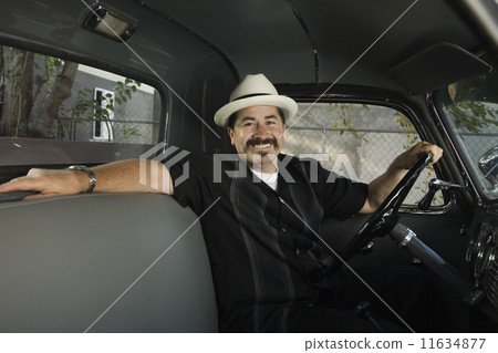 Hispanic man sitting in truck 11634877