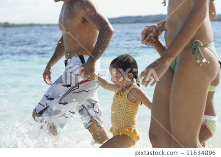 Hispanic family holding hands at beach Hispanic family holding hands at beach 11634896