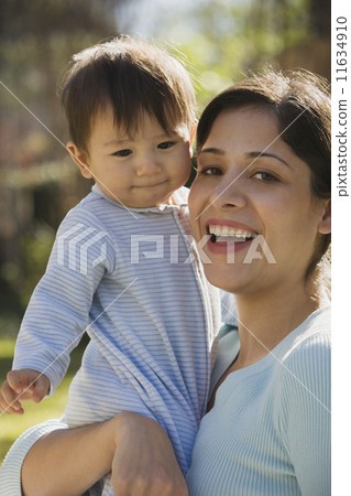 Close up of Hispanic mother holding baby outdoors Close up of Hispanic mother holding baby outdoors 11634910