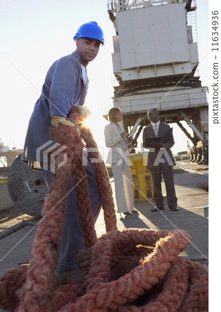 African American manual worker pulling rope African American manual worker pulling rope 11634936