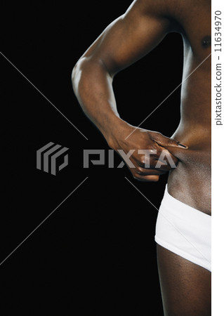 Semi-nude African man pinching waist 11634970