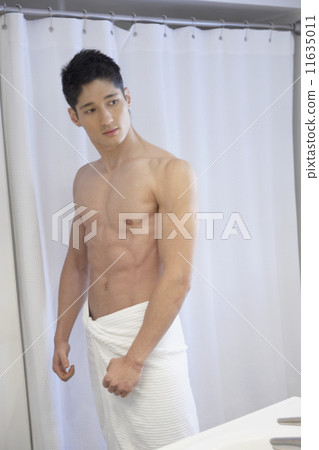 Asian man flexing in bathroom mirror Asian man flexing in bathroom mirror 11635011