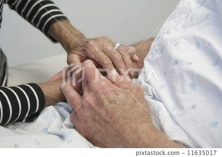 Close up of senior couple holding hands in hospital Close up of senior couple holding hands in hospital 11635017