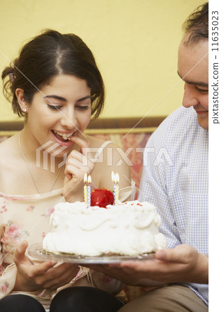Hispanic man giving girlfriend birthday cake Hispanic man giving girlfriend birthday cake 11635023