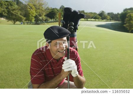 Hispanic man holding golf club Hispanic man holding golf club 11635032
