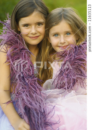 Two young girls wearing feather boa and smiling Two young girls wearing feather boa and smiling 11635113