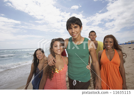 Multi-ethnic friends walking on beach 11635115