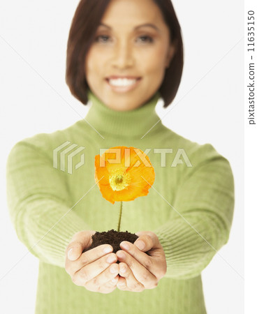 Asian woman holding flower in dirt 11635150