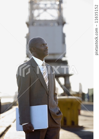 African American businessman holding laptop African American businessman holding laptop 11635152