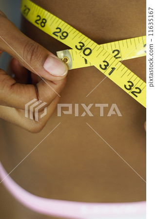 Close up of African woman measuring waist 11635167