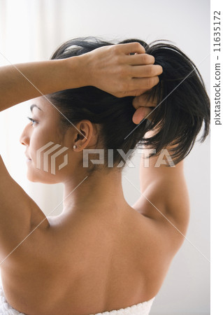 Rear view of woman pulling hair back Rear view of woman pulling hair back 11635172