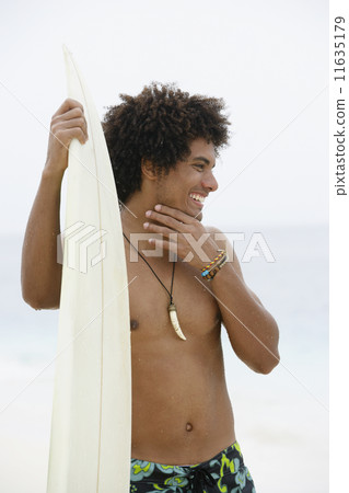 South American man holding surfboard 11635179