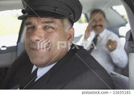 Portrait of chauffeur with businessman in car 11635181