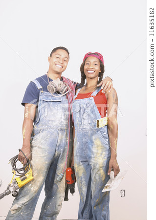 Portrait of couple in paint spattered overalls 11635182