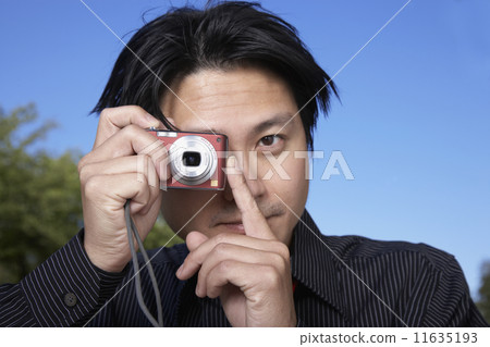 Asian man taking photograph Asian man taking photograph 11635193