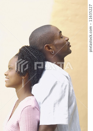 Young African couple standing back to back Young African couple standing back to back 11635227
