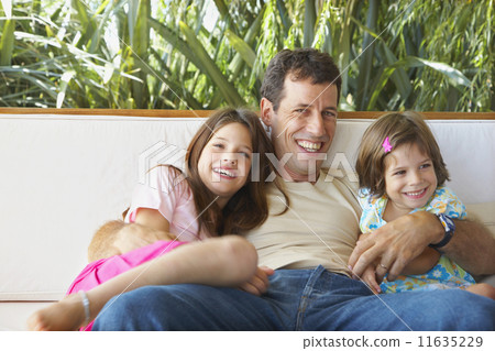 Hispanic father and daughters hugging 11635229