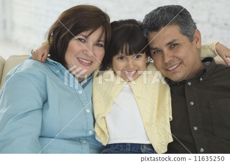 Hispanic parents and daughter hugging 11635250