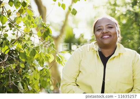 African woman smiling in woods 11635257