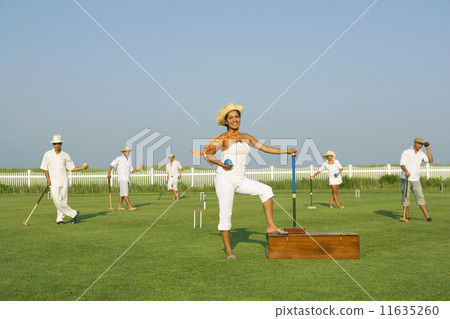 Multi-ethnic friends playing croquet 11635260