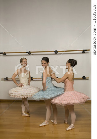 Hispanic female ballet dancers in studio 11635318