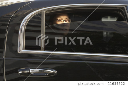 Asian woman in limousine with window part of the way down 11635322