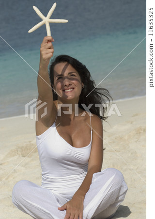 Hispanic woman holding starfish 11635325