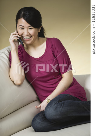 Asian woman talking on cell phone 11635333