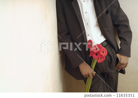 African American man in suit holding flowers 11635351