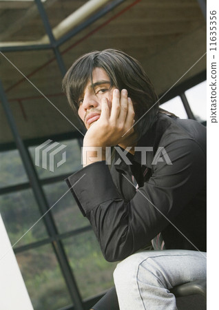 Hispanic man with chin in hand 11635356