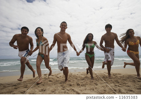 Multi-ethnic friends running on beach Multi-ethnic friends running on beach 11635383