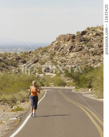 Senior Hispanic woman jogging 11635420