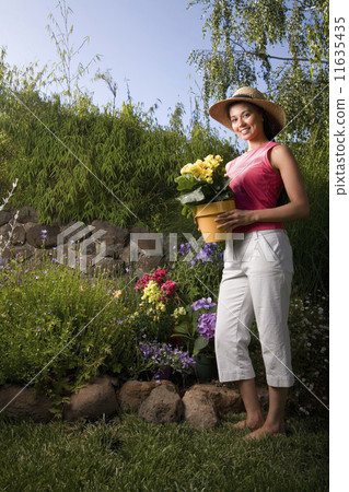 Mixed Race woman holding potted plant 11635435