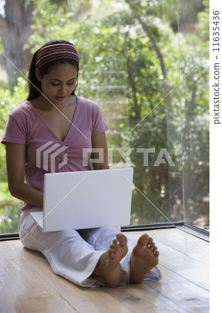 Young woman typing on laptop 11635436
