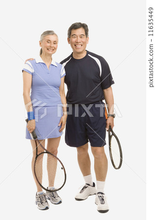Senior couple holding tennis rackets Senior couple holding tennis rackets 11635449
