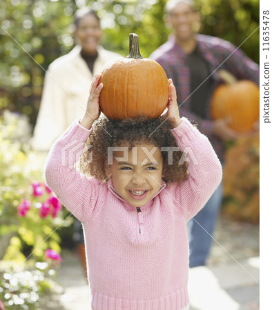 African girl holding pumpkin on head 11635478