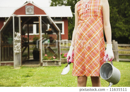 Girl holding gardening supplies on farm Girl holding gardening supplies on farm 11635511
