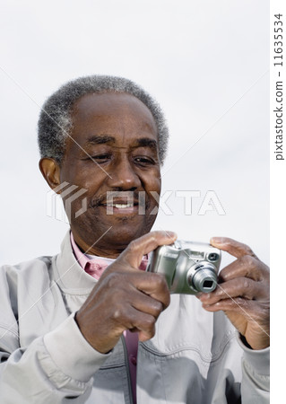Senior African man looking at digital camera 11635534