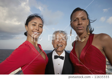 Senior man with two young women 11635555