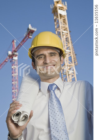 Hispanic businessman holding blueprints 11635556