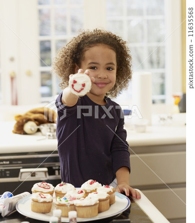 African girl holding decorated cupcake 11635568