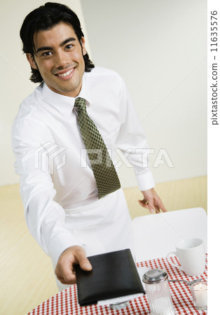 Mixed Race waiter handing over bill Mixed Race waiter handing over bill 11635576