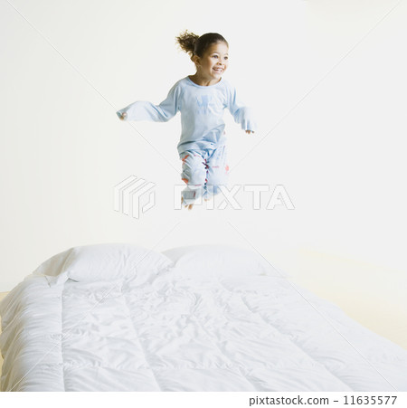 African girl jumping on bed 11635577