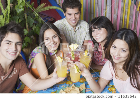 Young Hispanic friends toasting with cocktails 11635642
