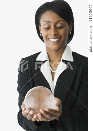 African businesswoman holding crystal ball 11635645